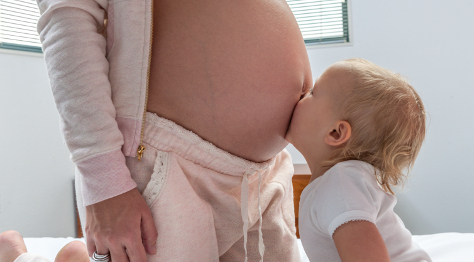 toddler kissing mum belly