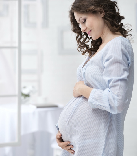 Pregnant woman looking at her bump