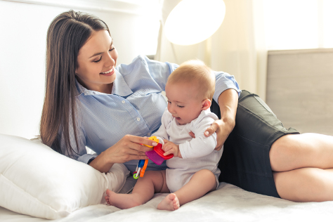 Mum in work suit playing with baby