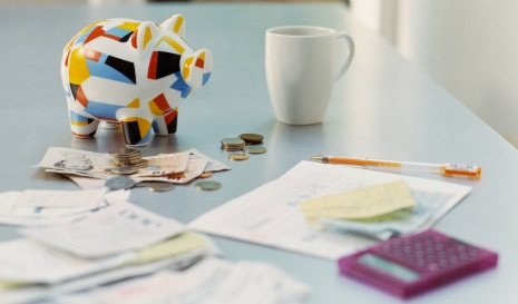An image of a piggy bank, money and calculator on a table