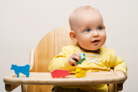 baby in wooden highchair