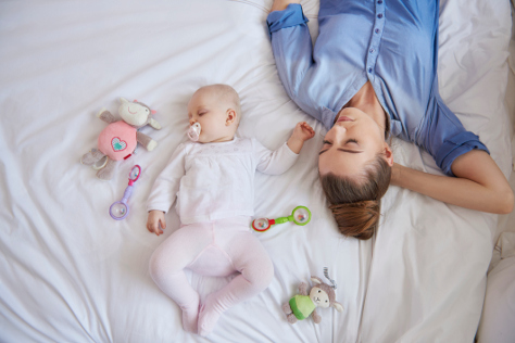 Stressed mum sleeping with baby