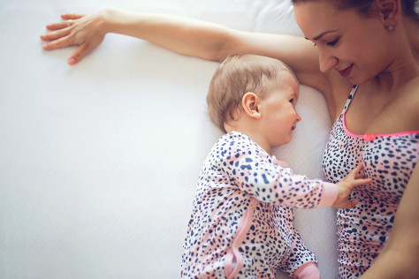 Mother and baby laying in bed