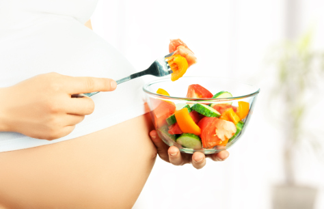 Pregnant woman with salad bowl