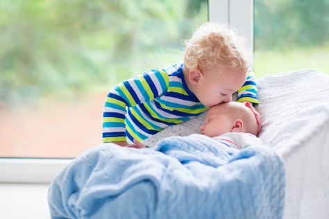 Age gap boy kissing baby brother