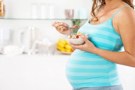 Pregnant woman eating fruit
