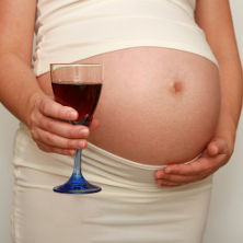 Pregnant woman holding glass of wine