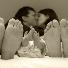 couple in bed with newborn