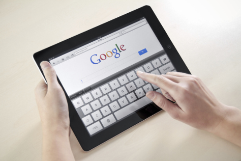 Woman typing in Google on iPad