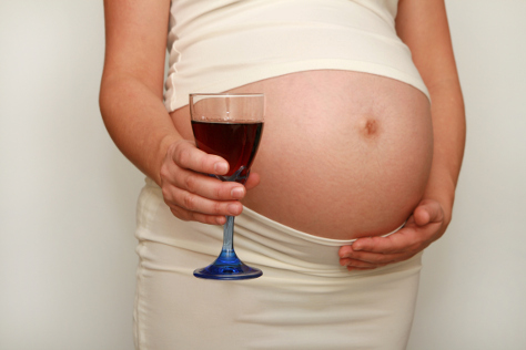 Pregnant woman holding glass of wine