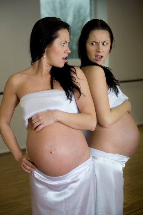 Pregnant woman looking in the mirror