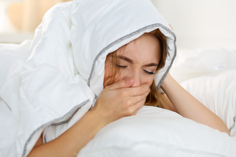 woman in bed feeling sick