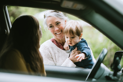 Mum in car grandparent and baby waving