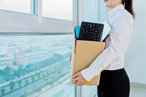 Woman carrying box of office belongings